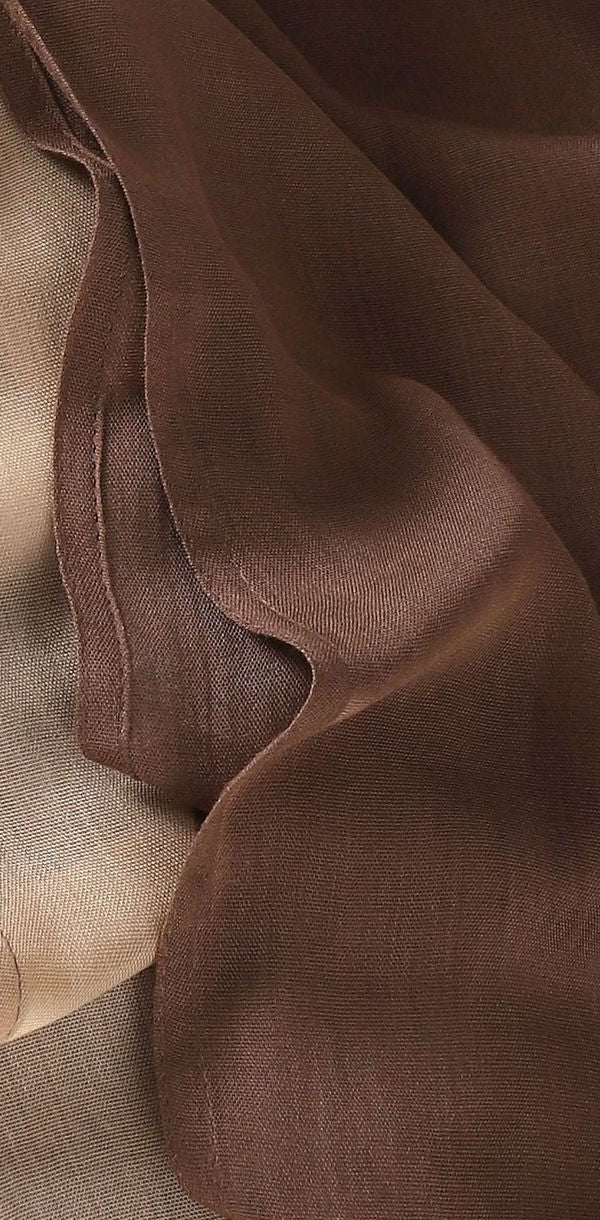 Close-up of cocoa brown and champagne hijab fabric with a stitched edge.